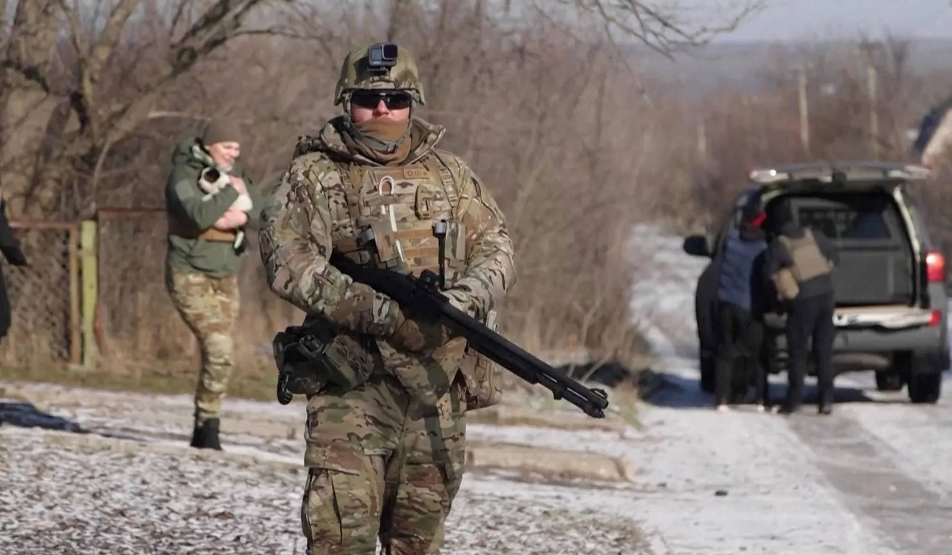 A Ukrainian national police officer, holding a shotgun used as a counter-drone weapon, stands on a lookout during an evacuation of residents from Tavriiske and Yurkivka villages in Ukraine's Zaporizhzhia Region