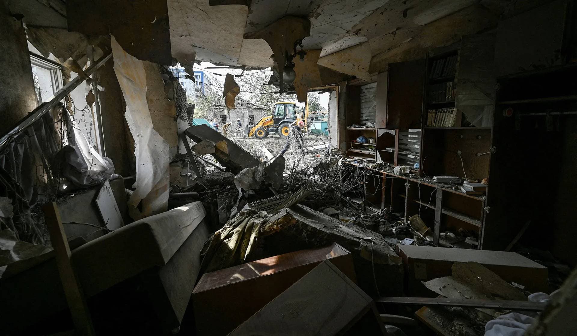A rescuer removes debris at a site of a residential area heavily damaged by a Russian air strike in Zaporizhzhia