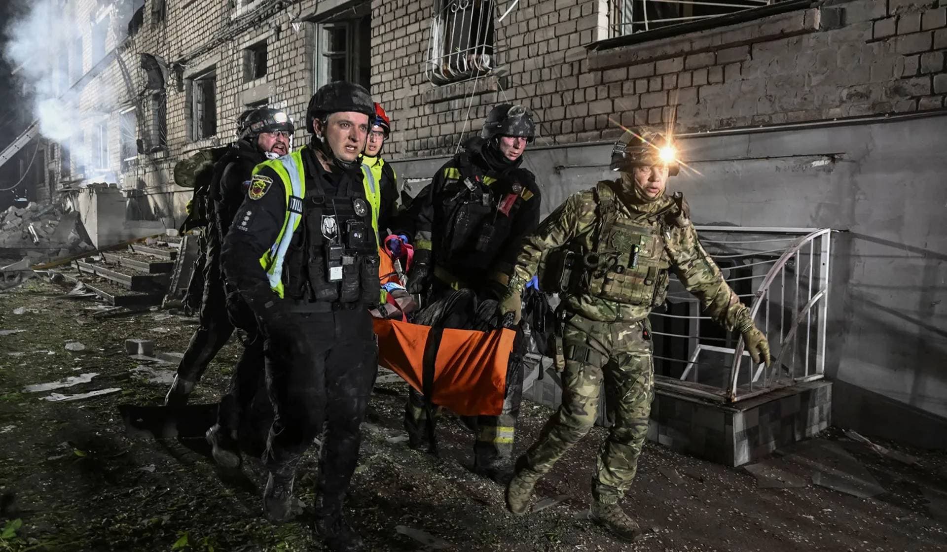 Rescuers evacuate a wounded resident from an apartment building damaged during a Russian drone strike in Zaporizhzhia