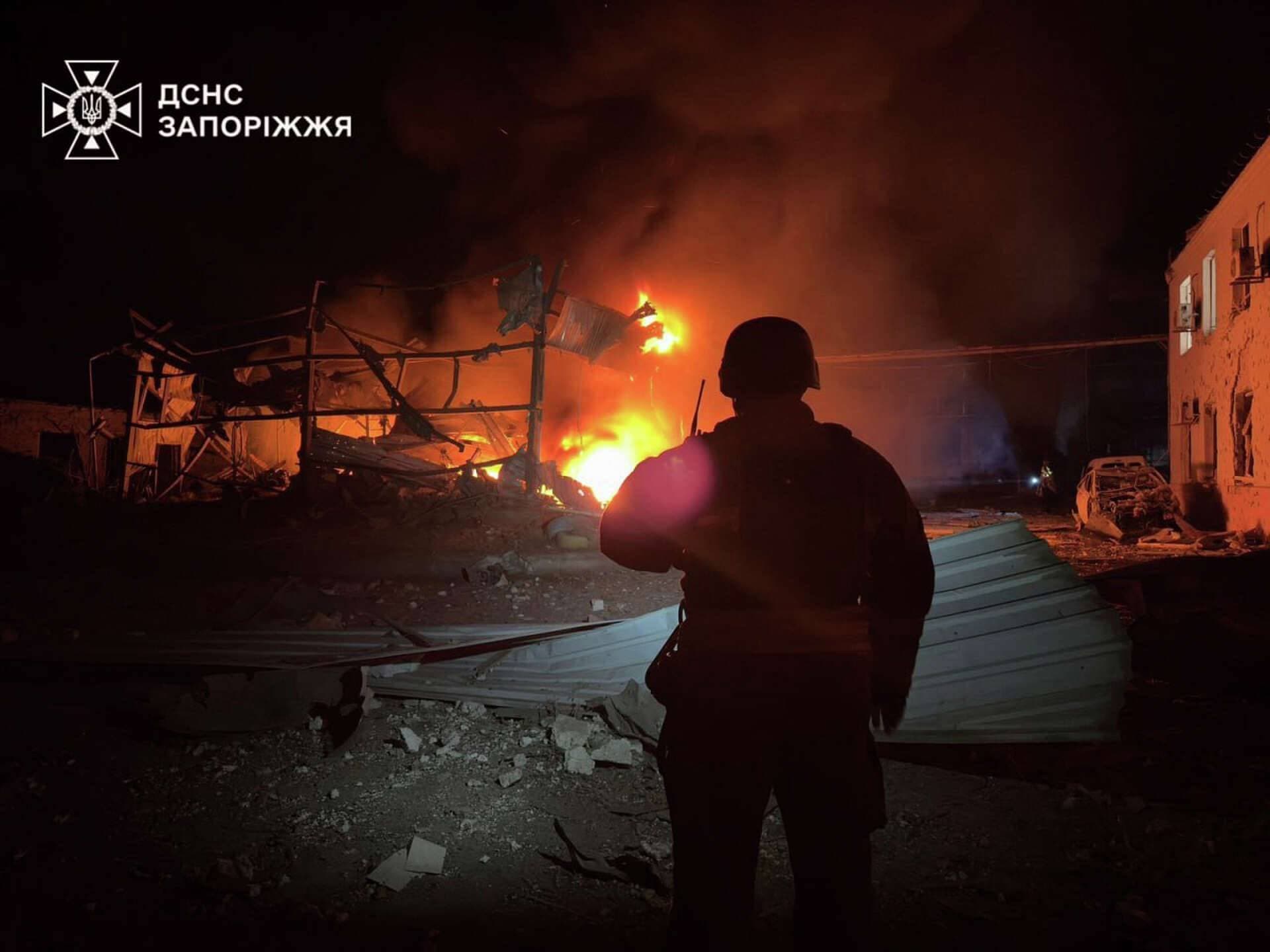 A firefighter looks at a building burning after it was hit during overnight Russian drone and air strikes in Zaporizhzhia