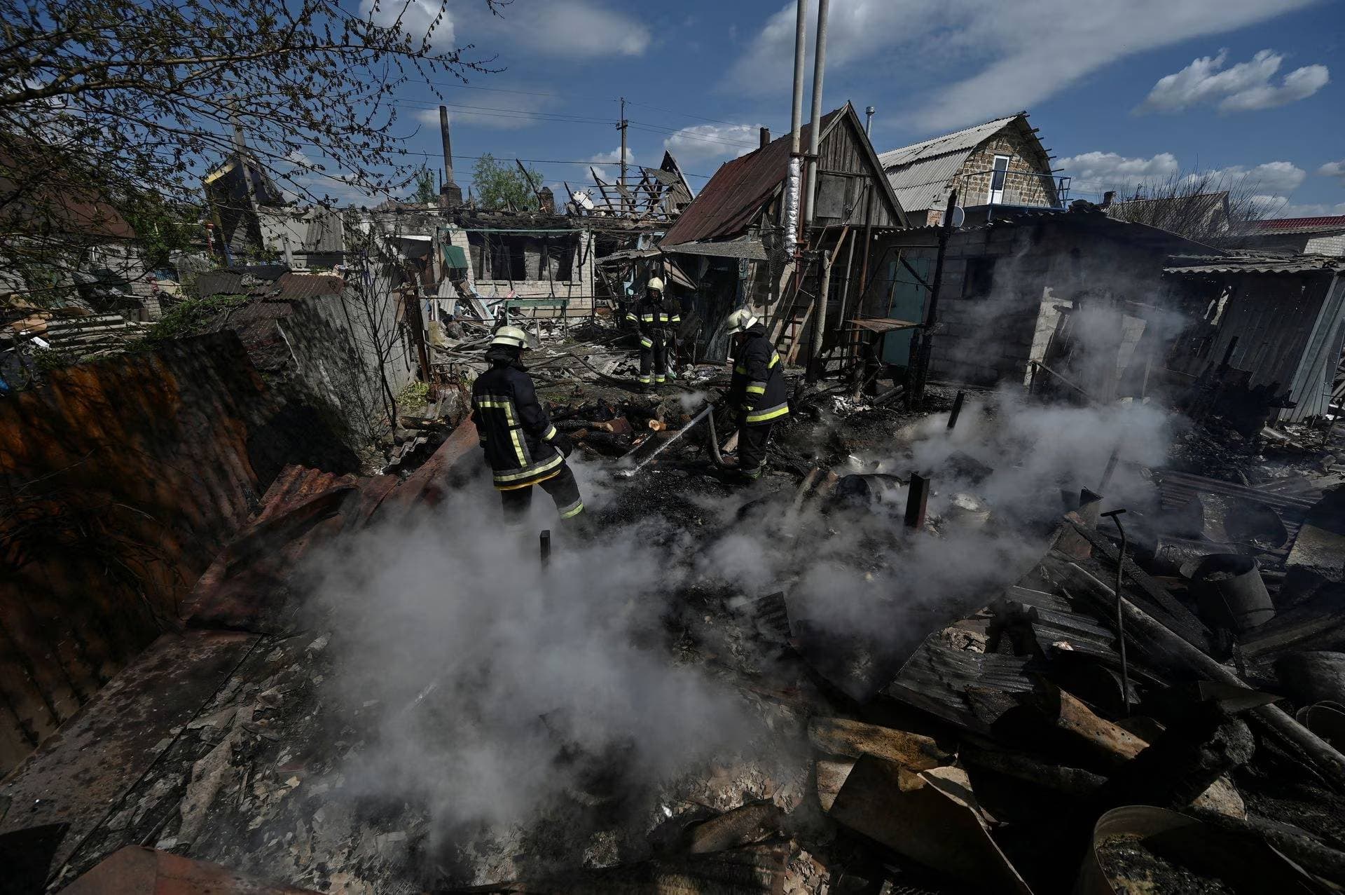Firefighters work at a site of a residential house destroyed by a Russian military strike in the village of Malokaterynivka