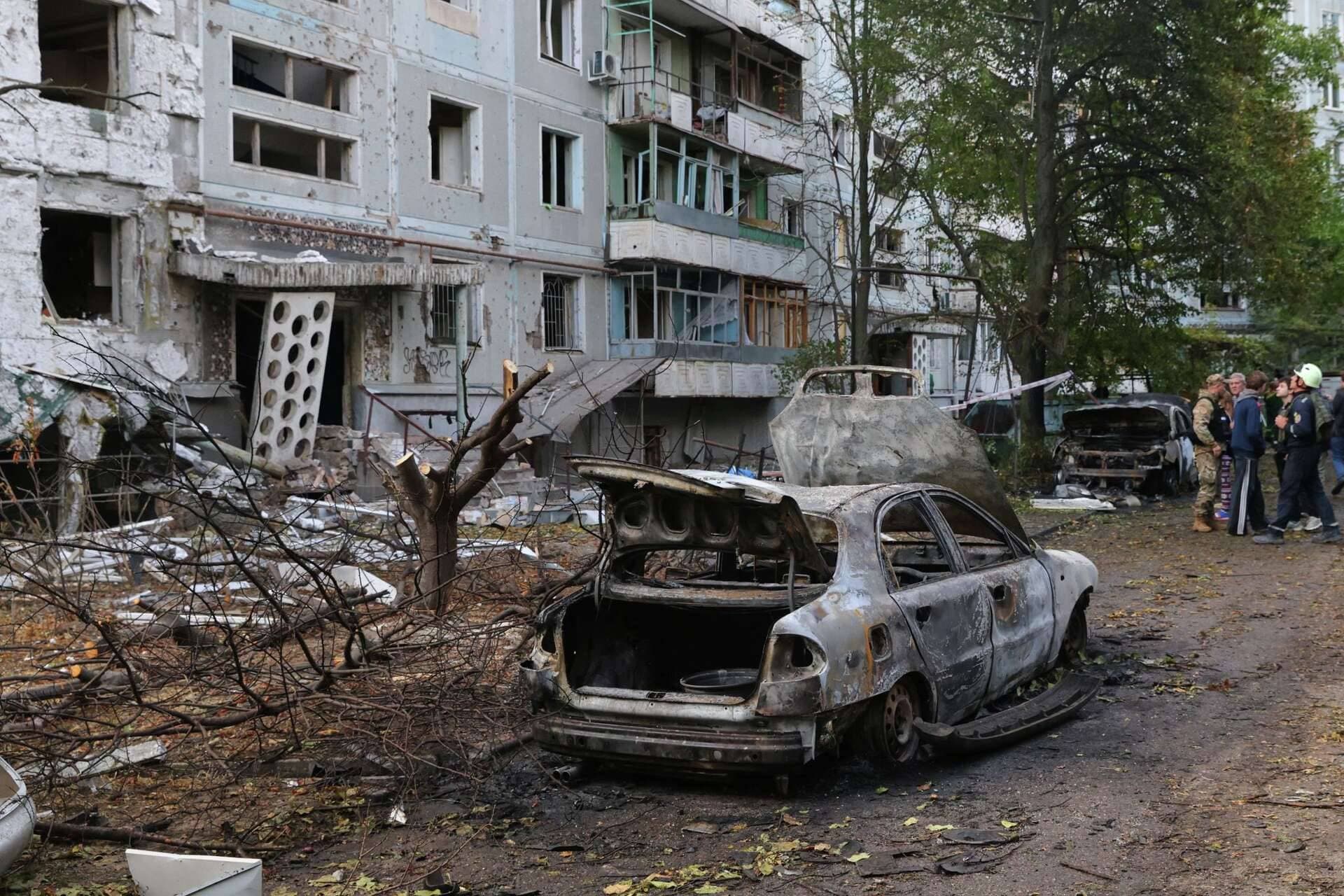 Burned cars and damaged residential building are seen after a Russian strike in Zaporizhzhia