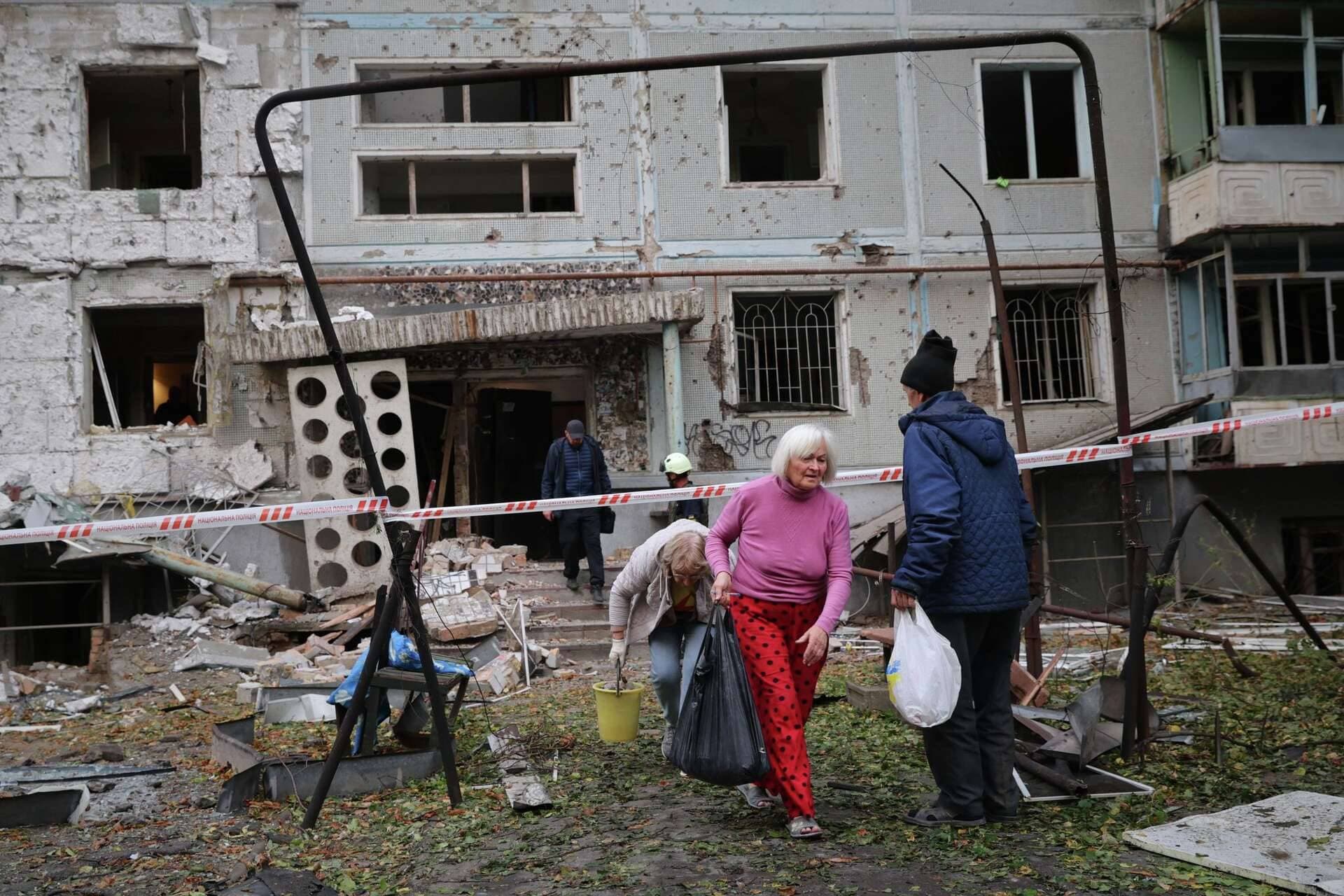 Residents take their belongings from their house destroyed by a Russian strike in Zaporizhzhia
