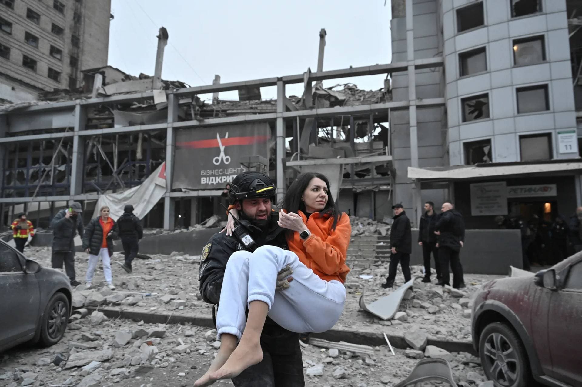 A police officer evacuates a woman from a building heavily damaged by a Russian missile strike in Zaporizhzhia
