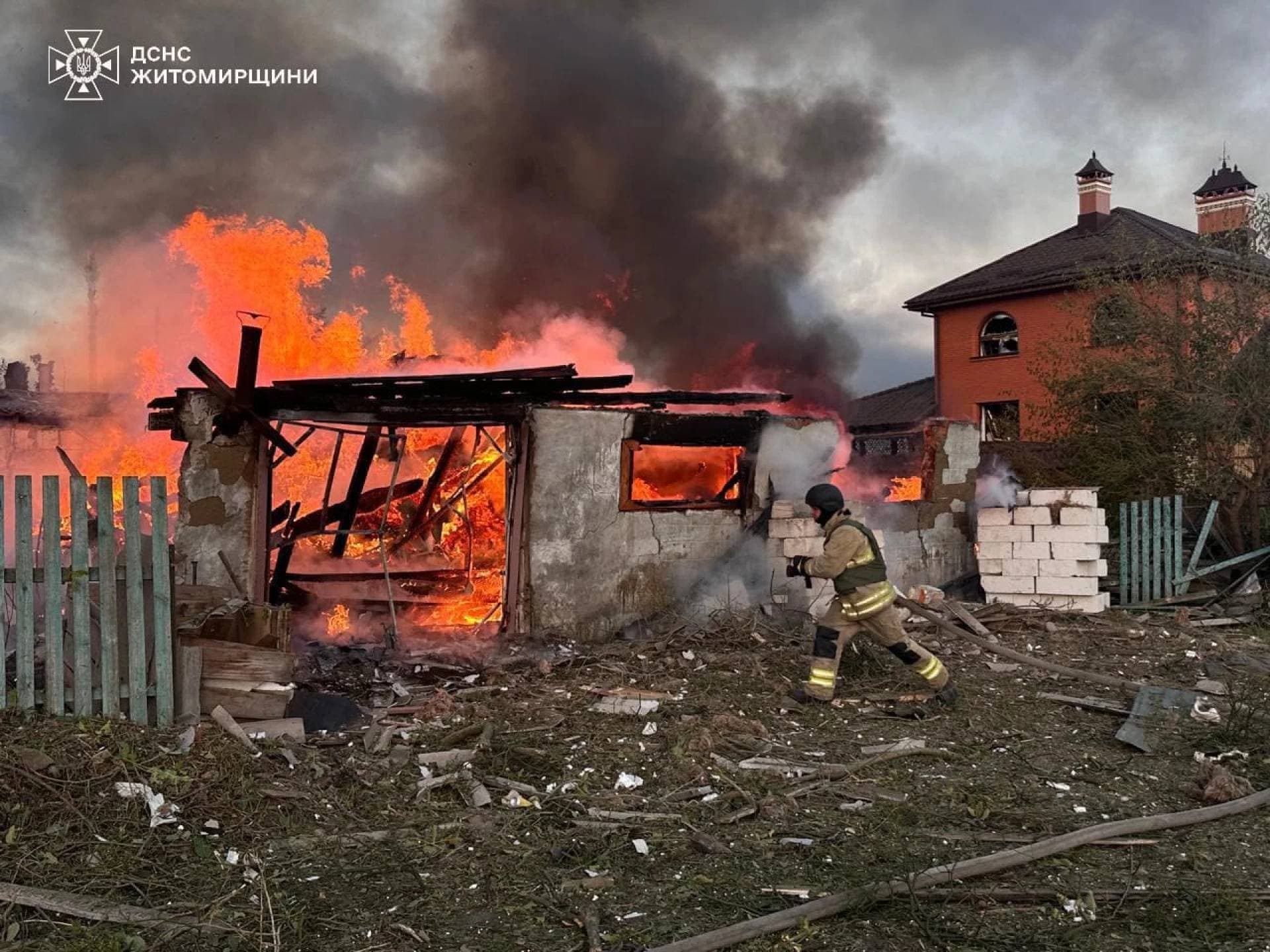 A firefighter runs at the site of a residential area hit during Russian drone and missile strikes in Zhytomyr Region
